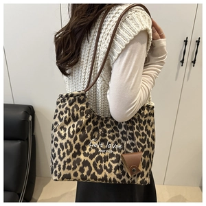 Detail shot of leopard print tote bag featuring C'eit lavse text and brown shoulder straps