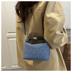 Détail du sac bandoulière léopard bleu avec boucles dorées et texture en suédine