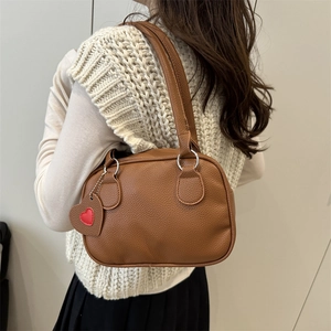 Brown litchi grain leather shoulder bag with a red heart pendant for women