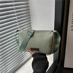 Mint green waterproof crossbody camera bag with wide fabric strap and fashion label