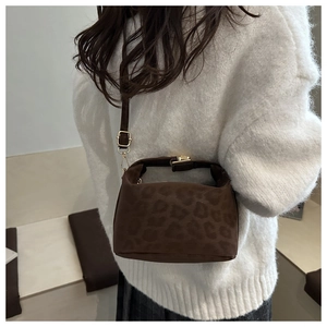 Detail of dark brown leopard print crossbody tote bag with adjustable strap on model