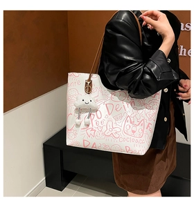 Dettaglio della borsa tote bianca con stampe graffiti rosa e ciondolo a nuvola