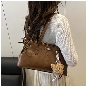 Sac fourre-tout vintage en cuir ciré marron porté à l'épaule pour montrer sa grande taille