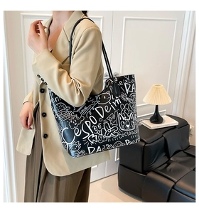 Dettaglio della borsa tote con stampa graffiti in pelle PU nera in un ambiente di vita reale