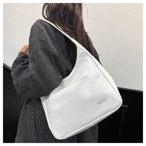 Close-up of white PU leather tote bag with gold fashion lettering on grey wool coat
