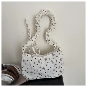 Detail of white corduroy bag with sweet care heart bow print and scrunchie strap