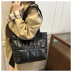 Detail of black quilted tote bag with glossy finish and durable nylon fabric