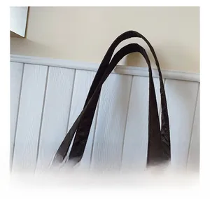 Close-up of the comfortable wide handle on this black quilted large tote bag