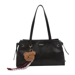 Classic black leather tote bag with long handles and a brown plush bear charm