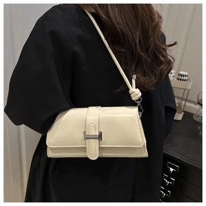 Close-up of knot shoulder strap and silver buckle on cream white square bag