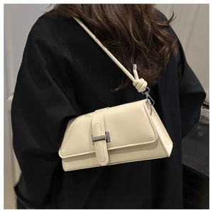 Chic beige rectangular baguette bag featuring a knotted strap and silver-tone metal clasp