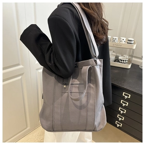 Model view of large grey canvas bucket bag showing strap length and spacious design