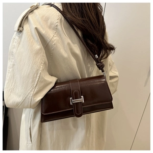 Détail du sac carré en cuir marron rétro avec finition cirée brillante et boucle argentée