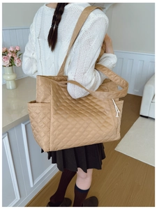Detail view of large caramel quilted tote bag featuring a spacious side pocket