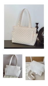 Detail view of large quilted tote bag with side pockets and front zipper pocket