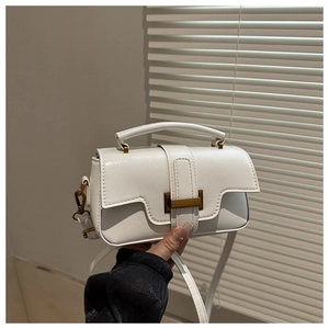 Detail of white PU leather texture and bronze rectangular buckle on a handbag