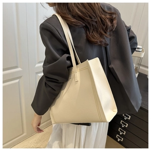 Dettaglio della borsa tote minimalista in pelle crema con texture a grana di litchi