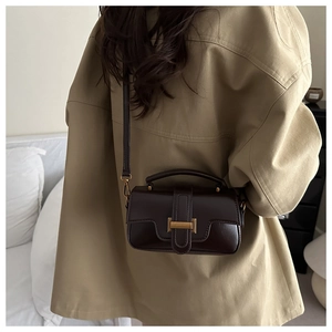 Detail view of dark brown faux leather crossbody bag with elegant gold metal buckle closure
