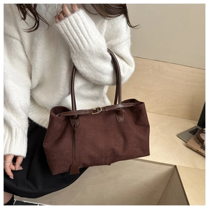 Close-up of deep brown suede tote bag with slim shoulder straps for autumn winter look