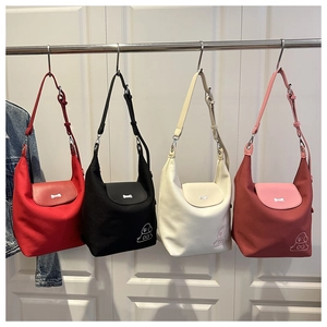 Detail view of four colorful canvas hobo bags featuring cartoon dog prints and bone buckles