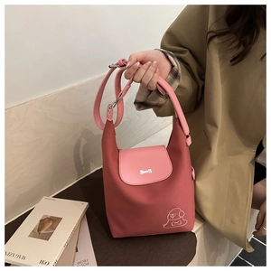 Detailed close-up of pink patchwork tote bag featuring cute dog embroidery and bone charm