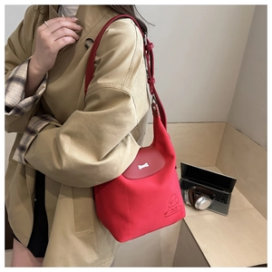 Detail of red hobo tote bag featuring a silver bone buckle and a cute puppy illustration