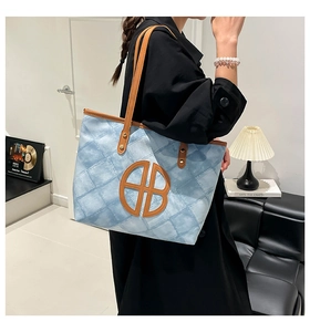 Detailed view of women's tote bag with blue gradient pattern and leather logo patch