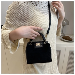 Detail of black Kelly bag showing matte texture stitching and gold metal twist lock