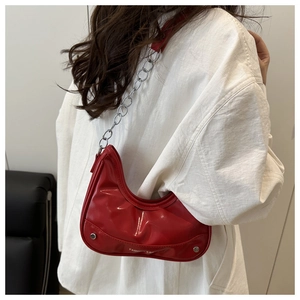 Detail of red crescent underarm bag with silver chain strap and printed lettering