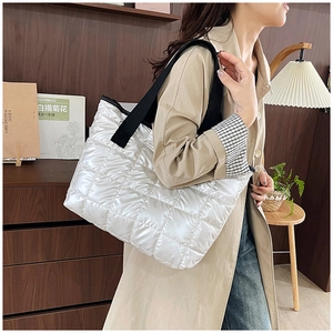 Détail d'un grand sac cabas matelassé blanc avec larges bretelles noires sur mannequin