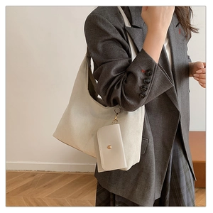 Detail of creamy suede hobo bag featuring a matching mini pouch with metal buckle