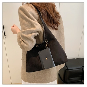 Detail of black suede tote bag with small leather pouch and golden metal hardware