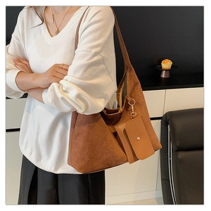 Brown suede tote bag with matching pouch shown on a model in a minimalist setting