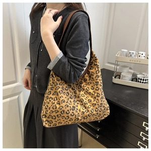 Close-up of leopard print oversized hobo bag on shoulder for vintage fall street style
