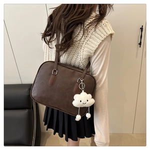 Close-up of brown PU leather Boston bag with a cute white cloud plush pendant
