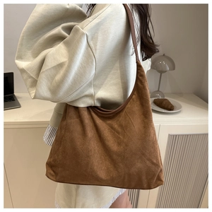 Brown suede large hobo tote bag shown on model in a minimalist lifestyle setting