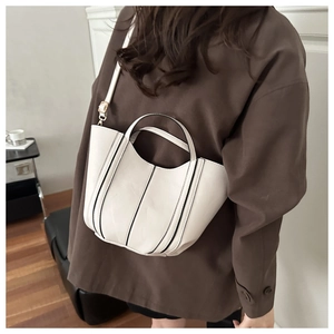 Détail du sac seau blanc avec bordures noires et bandoulière amovible réglable