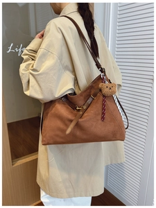 Dettaglio della grande borsa tote in pelle scamosciata marrone con tracolla in cuoio