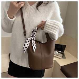 Brown litchi leather bucket bag detail with polka dot silk scarf and top handle