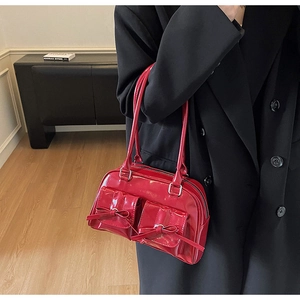 Macro detail of glossy red bow and front pockets on the ballet style shoulder bag
