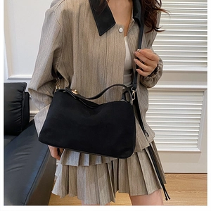 Detailed close-up of premium black matte shoulder bag with elegant gold hardware