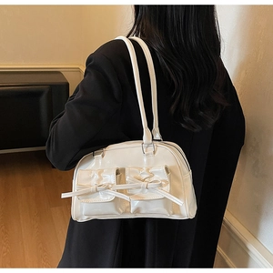 Détail du sac à bandoulière blanc crème brillant avec poches ornées de nœuds chic