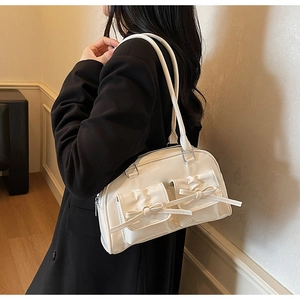 Détail du sac à main blanc style ballerine avec nœuds décoratifs et finition vernie