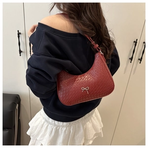 Détail du sac hobo bordeaux avec texture crocodile et boucle nœud argenté sur modèle