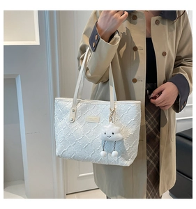 Detail of white tote bag featuring pleated texture and cute cloud charm accessory