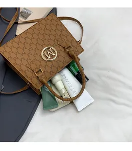 Dettaglio dell'interno spazioso di una borsa a tracolla marrone con monogramma
