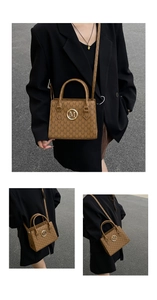 Dettaglio borsa marrone con monogramma M, logo dorato e tracolla versatile