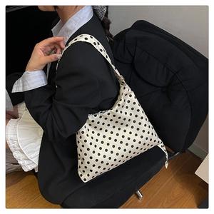 Polka dot shoulder bag shown as a stylish accessory with chic office attire