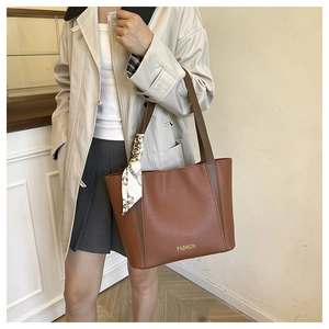 Sac cabas en cuir marron avec foulard en soie porté dans un style décontracté chic