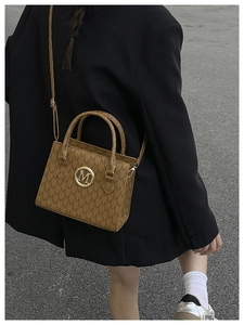 Detailed back view of a brown monogram tote bag featuring golden M logo and hardware